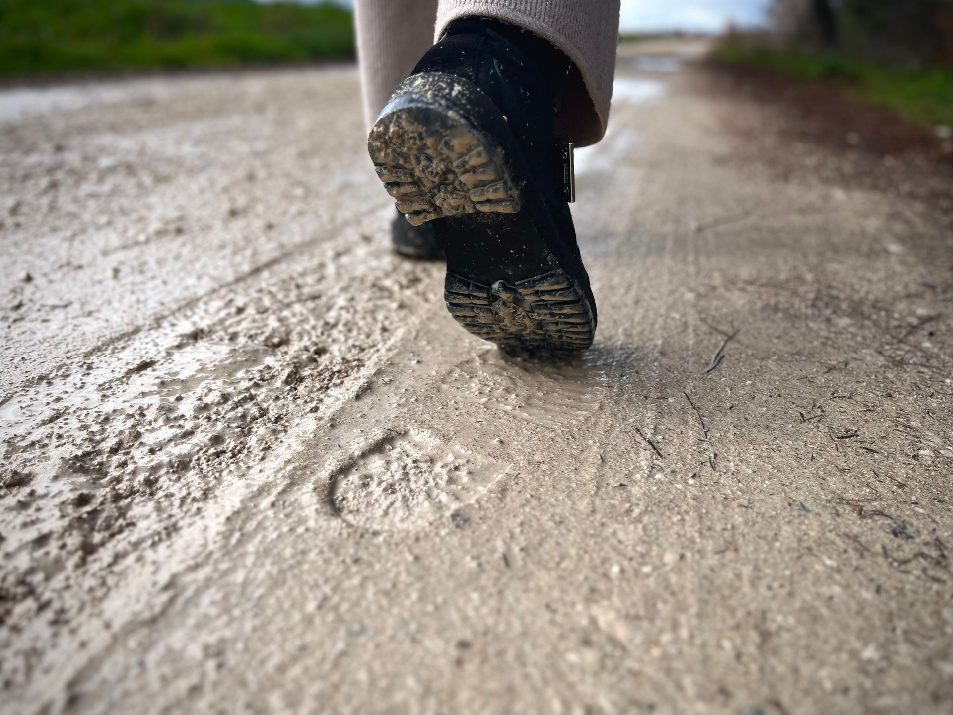 Close-Up of a Walking Step on a Muddy Rural Path with Footprints